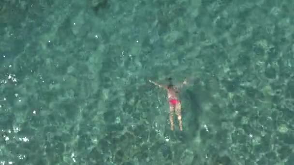 迷人的年轻女子来的空气 淹没和游泳在清澈透明的绿松石海洋水下 阳光穿透水表面露出石头 沙子在海底 — 图库视频影像