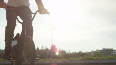 Ağır çekim Dof yakından: bmx bisiklet ve bir iş nollie hüner güzel bir yaz günü durdurma güneşli park, sürme aşırı bmx motorcu. Bir şehir sokak hileci performans tanınmaz bmx motorcu