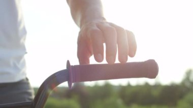 Ağır çekim Dof aşırı yakından: Ayrıntılarını bmx bisiklet donanımları, aşırı motorcu eller üzerinde gidon kulpları yerleştirerek. Bisiklet gidon, holding bmx motorcu şehirde binmek için hazırlık arkasında parlayan güneş