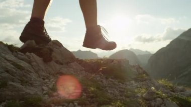 Ağır çekim, Close Up: geride tehlikeli kayalık dağ sırtı üzerinde yürüme dağın, tırmanma tanınmaz cesur kadın uzun yürüyüşe çıkan kimse. Dik duvar yüksek Avrupa Alpleri üzerinde güzel görünümü açma
