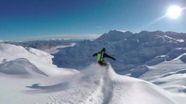 Yakın takip etmek: mutlu snowboard eğleniyor bir güneşli kış gününde snowboard backcountry karlı dağlarda. Taze kar kar bakırlı Dağı kayak merkezinde kapalı sürme aşırı freeride snowboarder