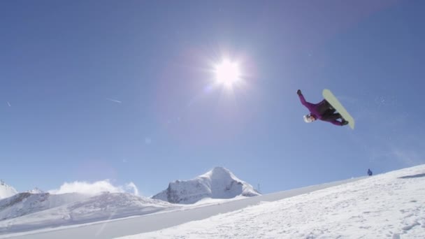 慢动作 年轻临滑雪板骑半管在大山雪公园 Halfpipe 墙和太阳 表演技巧和旋转与抓住在阳光明媚的冬天 — 图库视频影像