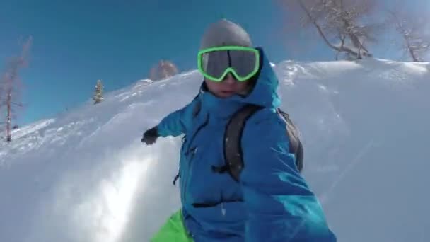Selfie 幸せなスノーボーダー楽しい晴れた冬の日に雪山でのバックカントリー スノーボード 雪山で極端なフリーライド スノーボーダー新雪パウダーに乗ってとやって粉になります — ストック動画