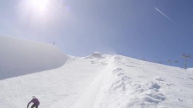 Ağır çekim: genç pro snowboard büyük dağ kar Park, sürgülü ve güneşli kışın halfpipe duvara Püskürtme yarım boru sürme