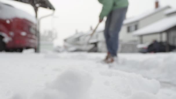 慢动作 家伙用铲子从街上铲起人工白雪 清理结冰的小路 冬季工作和去除深雪毯 扔在桩 — 图库视频影像