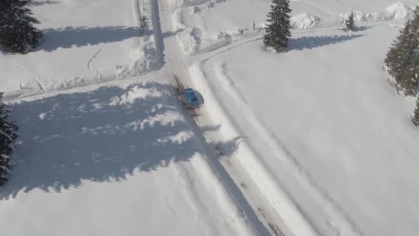 Aerial Carro Turquesa Dirigindo Rua Gelada Escorregadia Longo Cabanas Alpinas — Vídeo de Stock