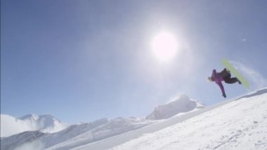 Ağır çekim: büyük dağ kar Park'ta yarım boru sürme, halfpipe duvardan ve güneş üzerinde atlama, hile ve rotasyonlar kapmak ile güneşli kışın gerçekleştirme genç pro snowboarder
