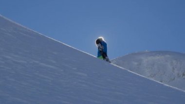 Ağır çekim yakın çekim: aşırı snowboard kışın yokuş yukarı doğru dağ Zirvesi taze toz karda hiking. Freeride snowboard deki dağın backcountry dağ kayak merkezinde tırmanma