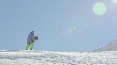 Ağır çekim yakın çekim: aşırı snowboard kışın yokuş yukarı doğru dağ Zirvesi taze toz karda hiking. Freeride snowboard deki dağın backcountry dağ kayak merkezinde tırmanma