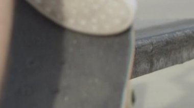 Ağır çekim Dof aşırı yakından: atlama ve sokakta beton bankta sürgülü tanınmaz kaykaycı. Patencinin kaykay bacaklar ve hile bir şehirde kaykay ile taşlama iş closeup