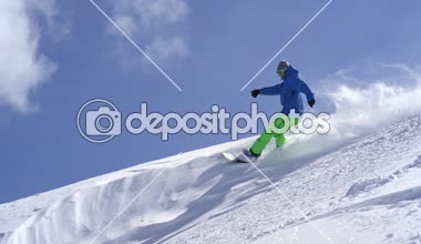 Ağır çekim yakın çekim: güneşli dağ backcountry kar püskürtme toz sürme ve toz döner, yapıyor Extreme snowboard. Eğleniyor snowboard bakırlı taze kar snowboard