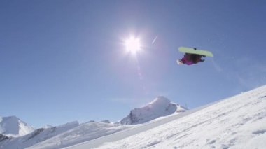 Ağır çekim: büyük dağ kar Park'ta yarım boru sürme, halfpipe duvardan ve güneş üzerinde atlama, hile ve rotasyonlar kapmak ile güneşli kışın gerçekleştirme genç pro snowboarder