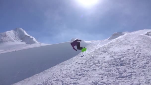 スローモーション 若いプロスノーボーダー大きな山スノーパークで半分の管に乗って ジャンプ ハーフパイプの壁から高 日当たりの良い冬のトリックやグラブの回転を実行します — ストック動画