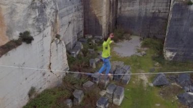 Hava, yakın: aşırı highliner highline derin kanyon, yaşam dolu dokuma ve düşen Tarih Dengeleme üzerinde yürüme yukarıda uçan. Emanet leash üzerinde erkek yavaşlatmak asılı ve kayalık uçurum üzerinde sallanan gülümseyen