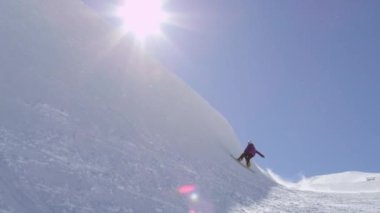 Ağır çekim: büyük dağ kar Park'ta yarım boru sürme, halfpipe duvardan ve güneş üzerinde atlama, hile ve rotasyonlar kapmak ile güneşli kışın gerçekleştirme genç pro snowboarder