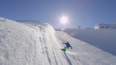 Ağır çekim: güneşli kışın kamerayı halfpipe duvar içine kar püskürtme büyük dağ kar Park, yarım boru sürme genç pro snowboard. Aşırı snowboard snowboard ve yapan.