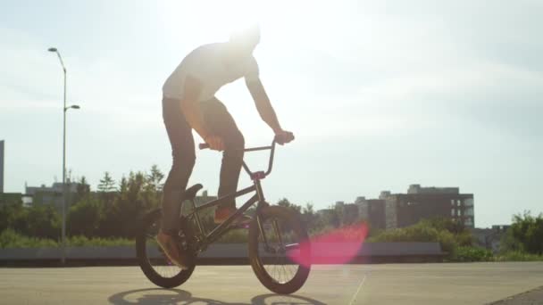 慢动作特写 在阳光明媚的公园里骑着自行车的超级小轮车手 在美丽的夏日 停了骑脚踏车和做 Nollie 的尾巴鞭子戏法 酷年轻的小轮车车手在城市街道上表演把戏 — 图库视频影像