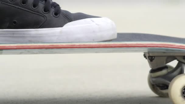 慢动作关闭 在阳光明媚的日子 在街道上 无法辨认的滑板滑板 滑板的腿和运动鞋的极端特写与轮子旋转的滑板甲板推 — 图库视频影像