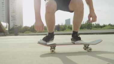 Ağır çekim yakın çekim: kaykay ve flip atlama tanınmaz kaykaycı ollie hüner beton sokak üstünde. Aşırı closeup kaykaycı'nın ayakları atlama kaykay ile hüner şehirde fiske vurmak