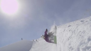 Ağır çekim: genç pro snowboard büyük dağ kar Park, sürgülü ve güneşli kışın halfpipe duvara Püskürtme yarım boru sürme