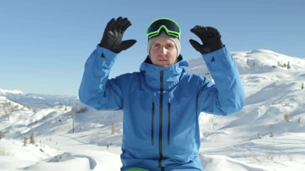 肖像慢动作特写 欢快的滑雪板准备滑雪在阳光山滑雪胜地 微笑的年轻滑雪者穿上他的滑雪护目镜在美丽的冬天天 — 图库视频影像