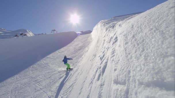 慢动作 临滑雪板骑半管在大山雪公园 滑动和喷洒雪在 Halfpipe 墙上阳光明媚的冬天 极端滑雪板滑雪板和表演技巧 — 图库视频影像
