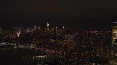 Midtown Manhattan siluetinin Hudson River Park ve waterfront lüks konut yukarıda doğru hava Heli Shot: uçan, Ofis Binası ve çağdaş gökdelenler ışıkları ile gece alev aldı.