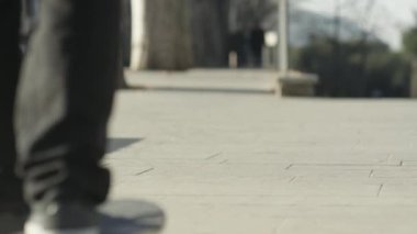 Kadar yakın, Dof: şehir merkezinde sokak kaldırım boyunca üzerinde güzel güneşli yaz günü seyir tanınmaz erkek kaykaycı binme kaykay. Paten güverte ve kaldırımda iplik tekerlekleri