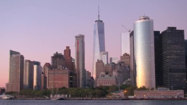 İkonik çağdaş cam gibi gökdelenler bir şafak mor pembe gökyüzü Aşağı Manhattan, New York City çarpıcı karşı yaktı. Büyülü gündoğumu, gelişmiş kentsel metropol modern mimarinin