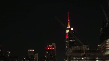 New York, Amerika Birleşik Devletleri - 24 Eylül: Kırmızı parlak neon tabela lüks New Yorker, Wyndham Hotel ile renkli ışıklar Empire State Binası anten Midtown Manhattan, New York City ile geceleri alev aldı.