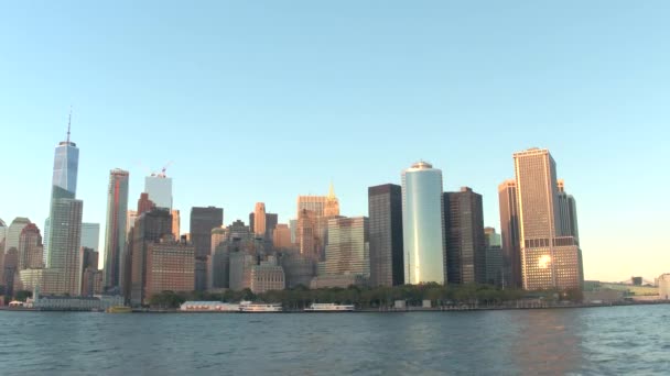 阳光反射在曼哈顿市中心的标志性摩天大楼在金色日落 著名的玻璃建筑和豪华公寓俯瞰纽约市海港 豪华游艇停泊在码头 — 图库视频影像