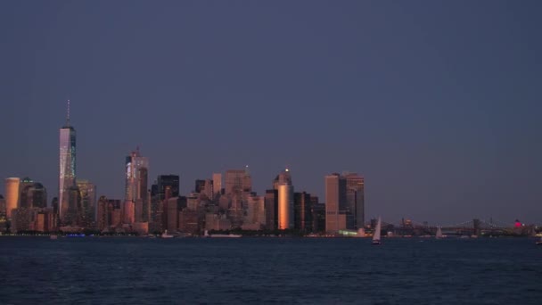 エスタブリッシング ショット 象徴的な現代ガラスの摩天楼マンハッタン ニューヨーク市の夜明けの見事な紫ピンクの空背景にライトアップされました 魔法の日の出で有名なニューヨーク金融街のスカイライン — ストック動画