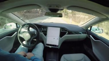 Özerk araba - 1 Şubat 2017: kırsal yolda araba özerk kendi kendine sürüş otomatik pilot Tesla Model S Sürücüsüz tüm elektrikli araba içinde Direksiyonun arkasında oturan erkek sürücü