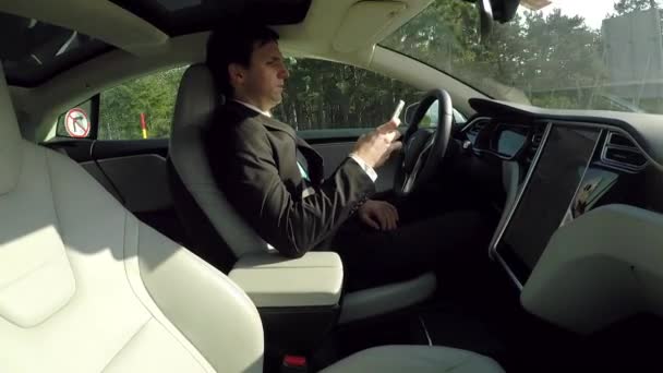 Tesla Autonoma Bil Mars 2017 Affärsman Skriver Meddelanden Smartphone Sitter — Stockvideo