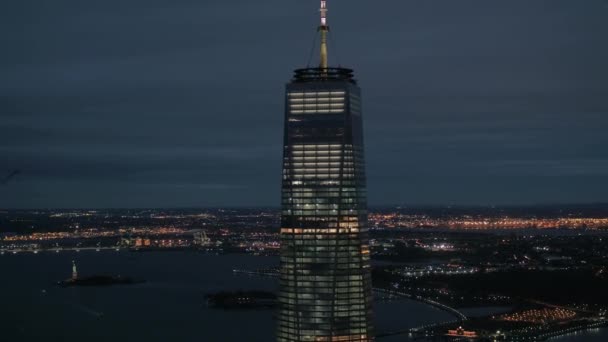 アメリカ合衆国ニューヨーク 2016 航空ヘリ撮影クローズ アップ ニュージャージーのライトでライトアップに対して つの世界貿易センターの高層ビルのオフィスをライトアップします バック グラウンドで自由の女神像をライトアップ — ストック動画