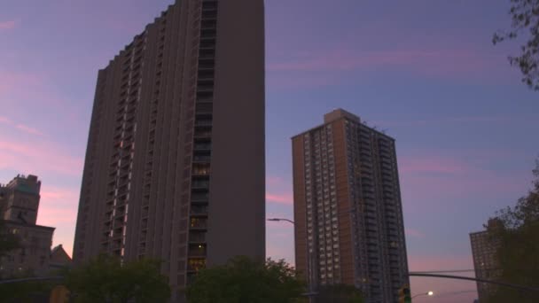 低角度看 高层高层住宅建筑和摩天大楼反对粉红色蓝天在黎明时分 在日出时驾驶过去纽约市中心的现代塔楼公寓 — 图库视频影像