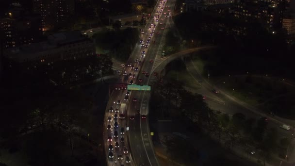 空中のヘリ ショット ダンボ近所ニューヨーク市過去の平たい箱の住宅街区の忙しいブルックリン橋橋地下道にライトでライトアップの上を飛んでください 夜通勤車 — ストック動画