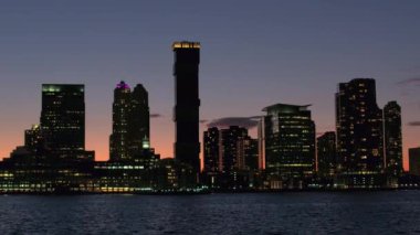 Büyülü şehir gece New Jersey parlayan ışıklar ile aydınlandı bakan tarafından Hudson Nehri üzerinde seyir. Windows konut kuleleri, düzlükler, gökdelenler ve karanlıkta shinning condominiums blokları