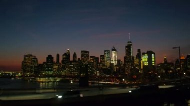 Yakın: Manhattan Köprüsü üzerinde sürüş bakan ikonik Brooklyn köprülü Kavsagi Interstate highway ve çağdaş cam gibi gökdelenler NYC şehir ışıkları ile şehir merkezine geceleri ışıklı