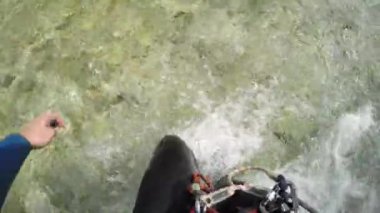 Pov, Close Up: Tanınmaz adam kayalık nehir yatağına yürüme, suya yatarak ve nehir den aşağı hızlı su yolu ile inen. Adam yüzeyde yüzen ve akış ile yüzme