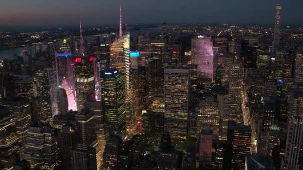 ニューヨーク アメリカ合衆国 2016 夕暮れ時に高いガラス高層ビル間明るく照らされたタイムズ スクエアの撮現代的な高層ビルやマンションの輝く夜に — ストック動画
