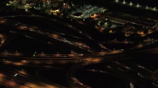 空中直升机射击 飞行在上面点燃与灯巨型的多水平互换路连接点在高速公路与在舷梯和舷梯 商业区密集的交通 夜间行驶的车辆 — 图库视频影像