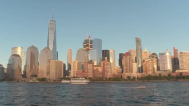 Manhattan kent merkezinin içinde ikonik gökdelenler altın günbatımında yansıtan güneş ışığı. Ünlü cam gibi binalar ve New York City liman manzaralı lüks condominiums. Kürek ve touring Lüks Yatlar