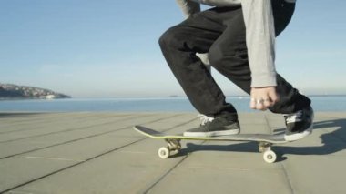 Ağır çekim, Close Up, Dof: kaykay ve 360 flip hüner okyanus boyunca güneşli yaz aylarında atlama tanınmaz kaykaycı. Kaykaycı binme kaykay Kickflip hüner atlama