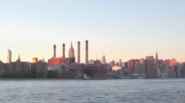 Doğu Nehri'ne bakan Doğu Köyü manzarası Manhattan, New York şehir uzun bir ofis binaları ve kurumsal gökdelenler ile mahalle üzerinde seyir yükselen güneş parlak ışıklarla alev aldı.