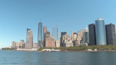 Manzarası cruise Battery Park, ünlü uzun cam gibi gökdelenler, tarihi binalar ve güneşli New York'un Downtown Manhattan Hudson Nehri manzaralı daireler lüks konut blok boyunca