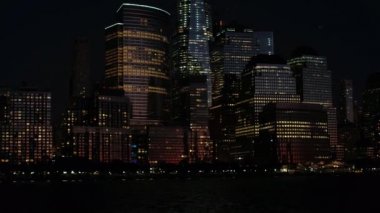 Yakın: Office windows üzerinde uzun boylu camsı gökdelenler hiç uyumayan şehir ışıkları ile aydınlatılmış. Büyülü Downtown Manhattan finansal bölgesinde gece New York'ta parlayan şehir ışıkları