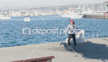 Yakın: kaykay ve güneşli günde 180 ollie, shov-BT ve kickflip hüner Okyanus sahili boyunca atlama Pro kaykaycı. Serin patenci Ollie'de ve flips seaside, beton ve kıyı atlama