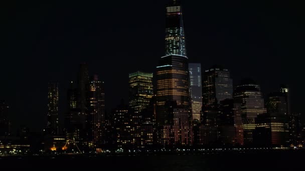 眠らない街のライトで照らされた背の高いガラスの高層ビルにオフィスの窓をクローズ アップ 魔法マンハッタンのダウンタウン金融街で夜ニューヨーク市で輝く街の明かり — ストック動画