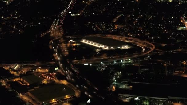 空中合力射击上面点燃了与灯光巨大的多电平交汇路口 汽车沿公路行驶在大都市城的商业和住宅区连接夜间 — 图库视频影像